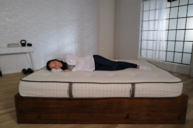 Avocado Organic Latex Mattress lying on it by the tester