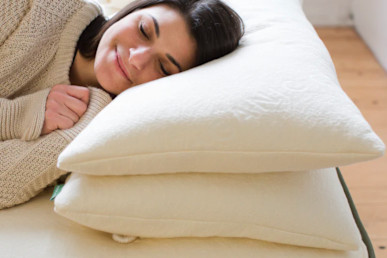 A woman sleeping with an Avocado Green Pillow