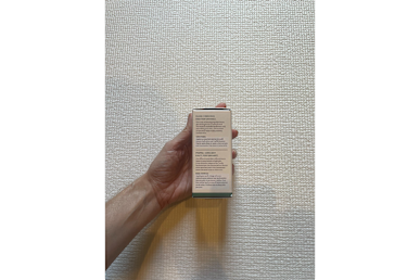 Biossance Squalane + Copper Peptide Rapid Plumping Serum box held in a tester's hand against the wall side surface of the box