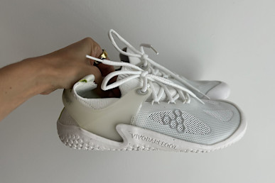 writer's hand holding up the Vivobarefoot Motus Strength shoes