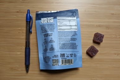 Lazarus Naturals cbd calm gummies back of bag next to pen to show size of 10-count bag