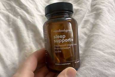 mindbodygreen sleep support+ bottle in hands almost empty