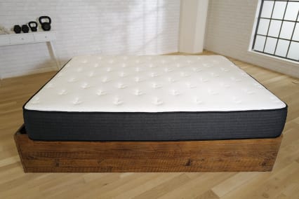 Best Extra-Firm Brooklyn Bedding Plank Mattress on brown baseboard in testing stuido