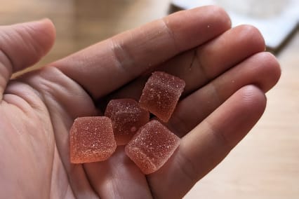 Naternal Ease CBD Gummies in hand with four gummies