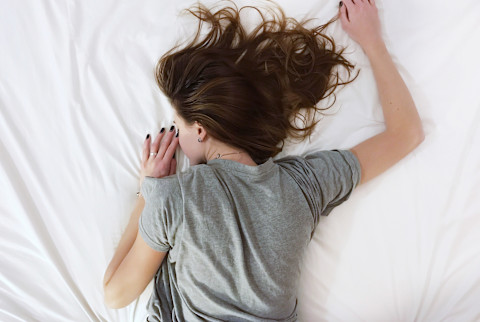 woman laying on stomach in bed