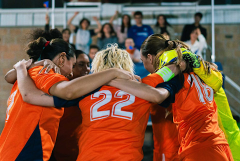 Women huddling with their team Women huddling with their team