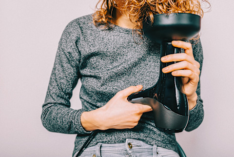 a woman with curls using a diffuser a woman with curls using a diffuser