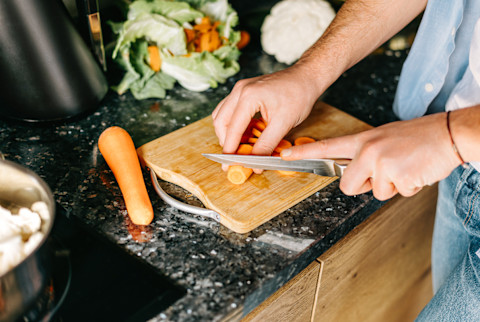 Man Chopping Carrots on a Counter