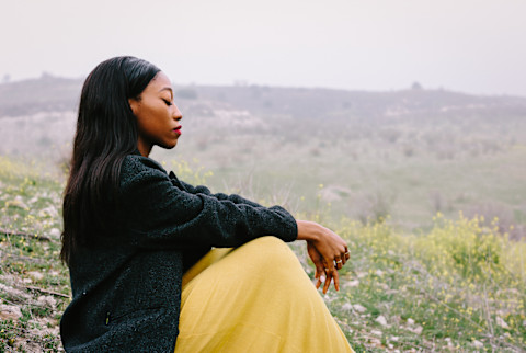 Woman Meditating in a Field in the Spring
