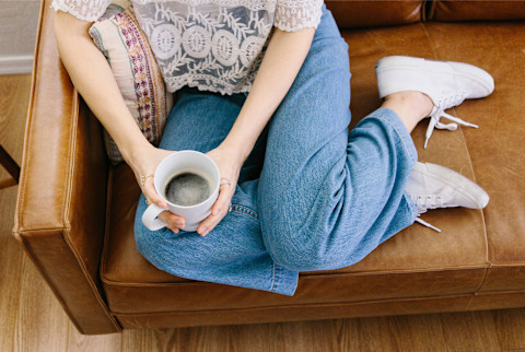 woman holding coffee on the couch