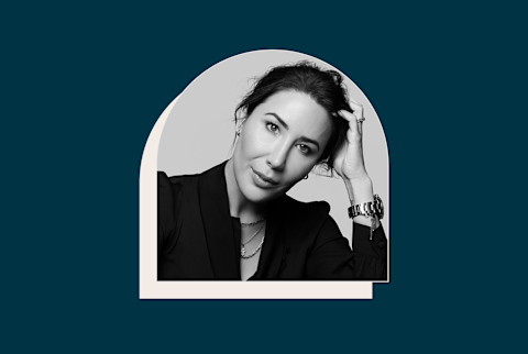 black and white photo of a woman resting her head on her hand with a navy blue background