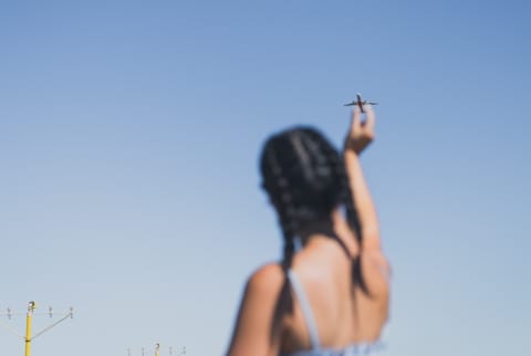 artistic perspective shot of woman seemingly touching an airplane artistic perspective shot of woman seemingly touching an airplane