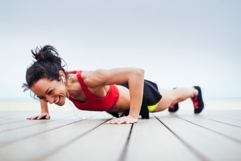 stock image of woman doing push up smiling