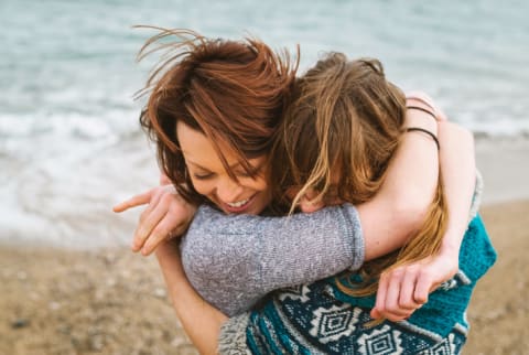 Image of two friends embracing. Human connection is a basic emotional need.