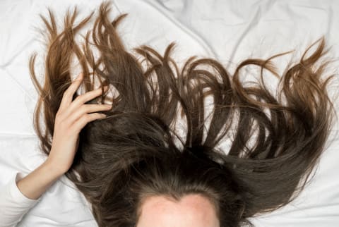womans hair laying on bed 