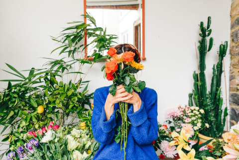 Florist Holding a Bouquet of Flowers In Front Of Her Face