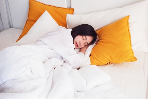 Woman Sleeping Against Pillows