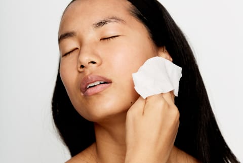 Asian woman washing face with a cloth