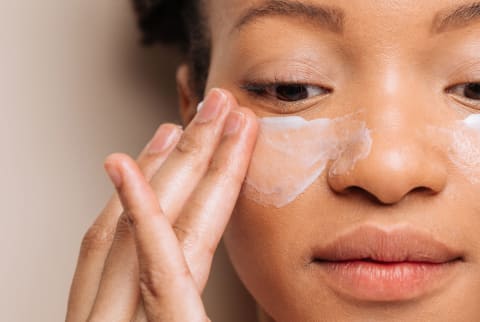 woman putting on skincare