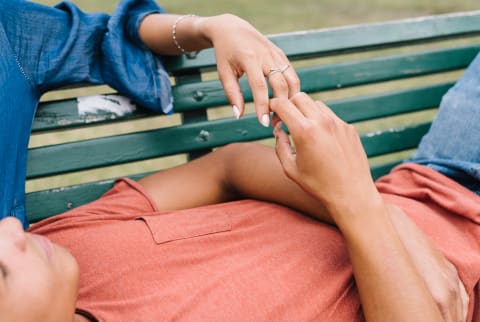 Couple Holding Hands On a Park Bench