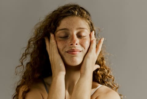 woman touching her face