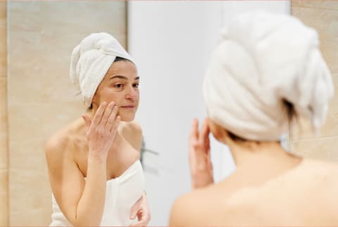 woman touching face in mirror woman touching face in mirror