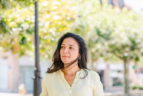 woman walking outdoors in a yellow shirt