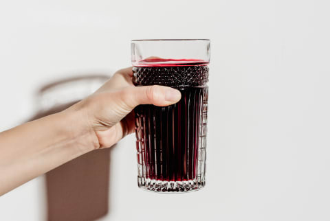 Hand Holding a Glass of Freshly Squeezed Beet Juice