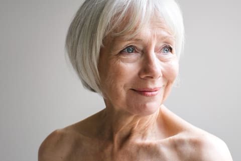 Older woman with gray hair on a white background