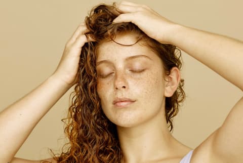 Woman massages serum/oil into scalp