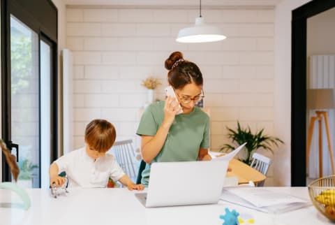 Mother Multitasking on the Phone with Work and Her Young Son