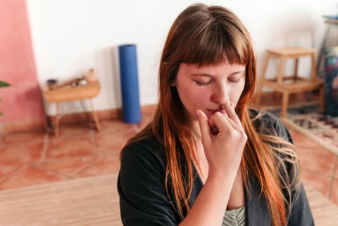 woman holding her nose for alternate nostril breathing