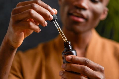 Young Man with CBD Oil Bottle
