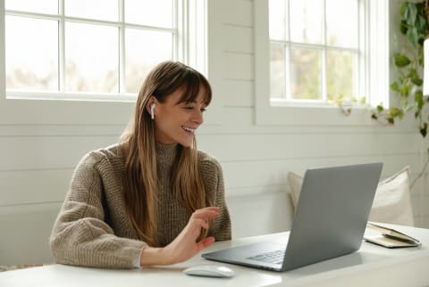 Woman Working at her laptop with ear buds in