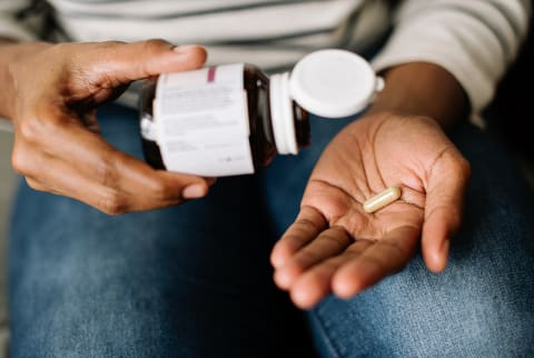 Hands Pouring Out Supplement Pills