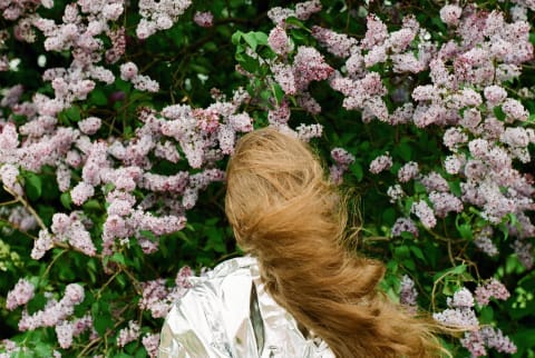 Woman standing in front of lilac bush