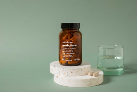 Metabolism+ product image with capsules and water glass