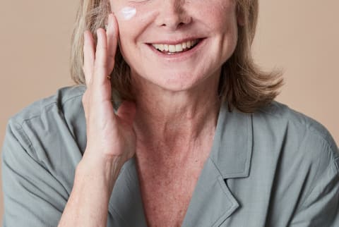 Unrecognizable Woman In Her 50s Applying Moisturizer to Her Face