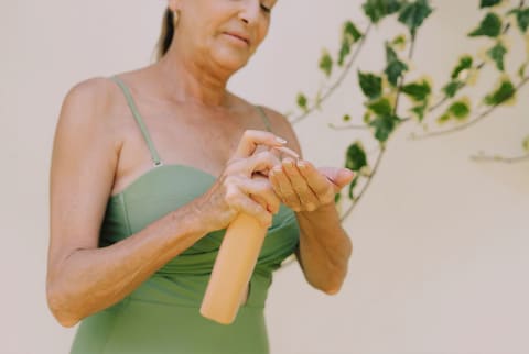Woman applying body lotion