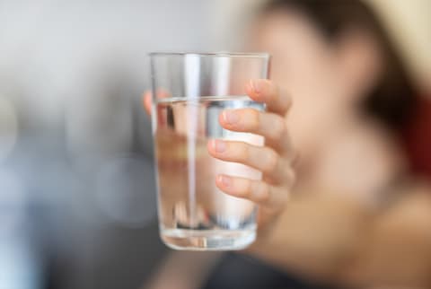 woman holding a glass of water