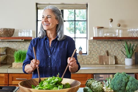 older woman mixing up a salad