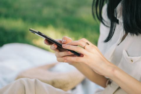 Woman Texting on Her Phone in a Park