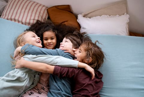 Kids in a bed hugging 