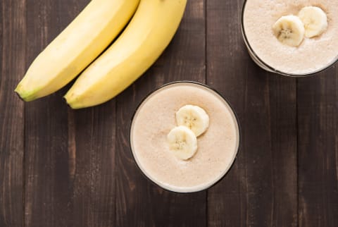 Top shot banana smoothie on wooden table