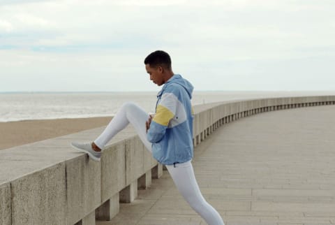 Woman exercising outside by the ocean / beach during fall / winter