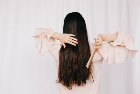 woman brushing long brown hair