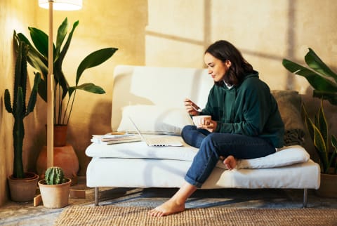 Woman Sitting on Couch Eating Cereal