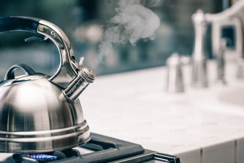 Tea Kettle Boiling on a Kitchen Stove