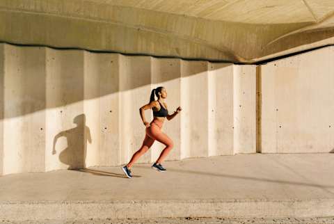 Athletic Woman Running On Street In Sunlight Athletic Woman Running On Street In Sunlight
