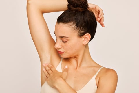 woman looking at her underarm